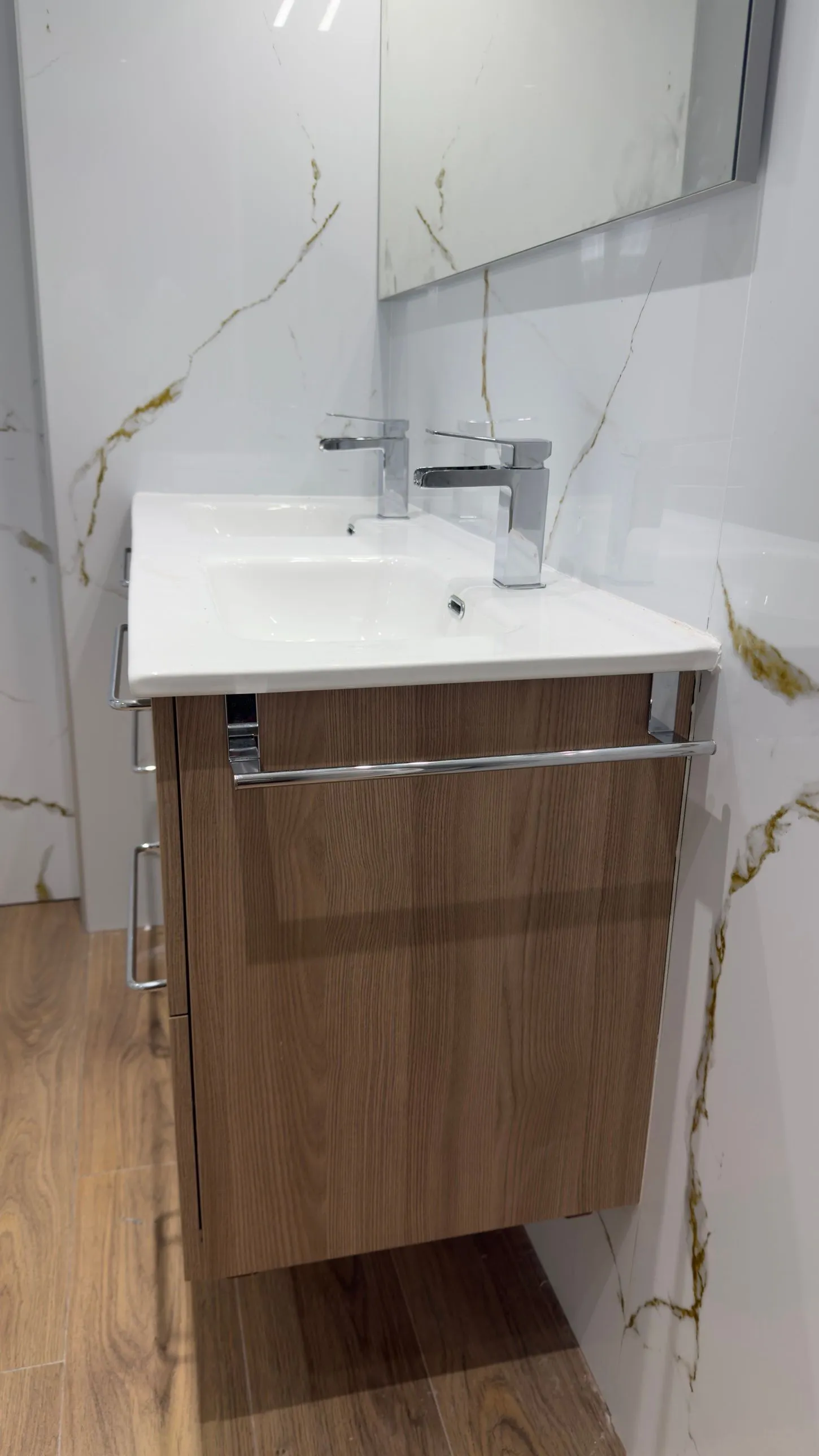 Lateral del mueble de baño suspendido con toallero, sobre el revestimiento Kobert In efecto mármol