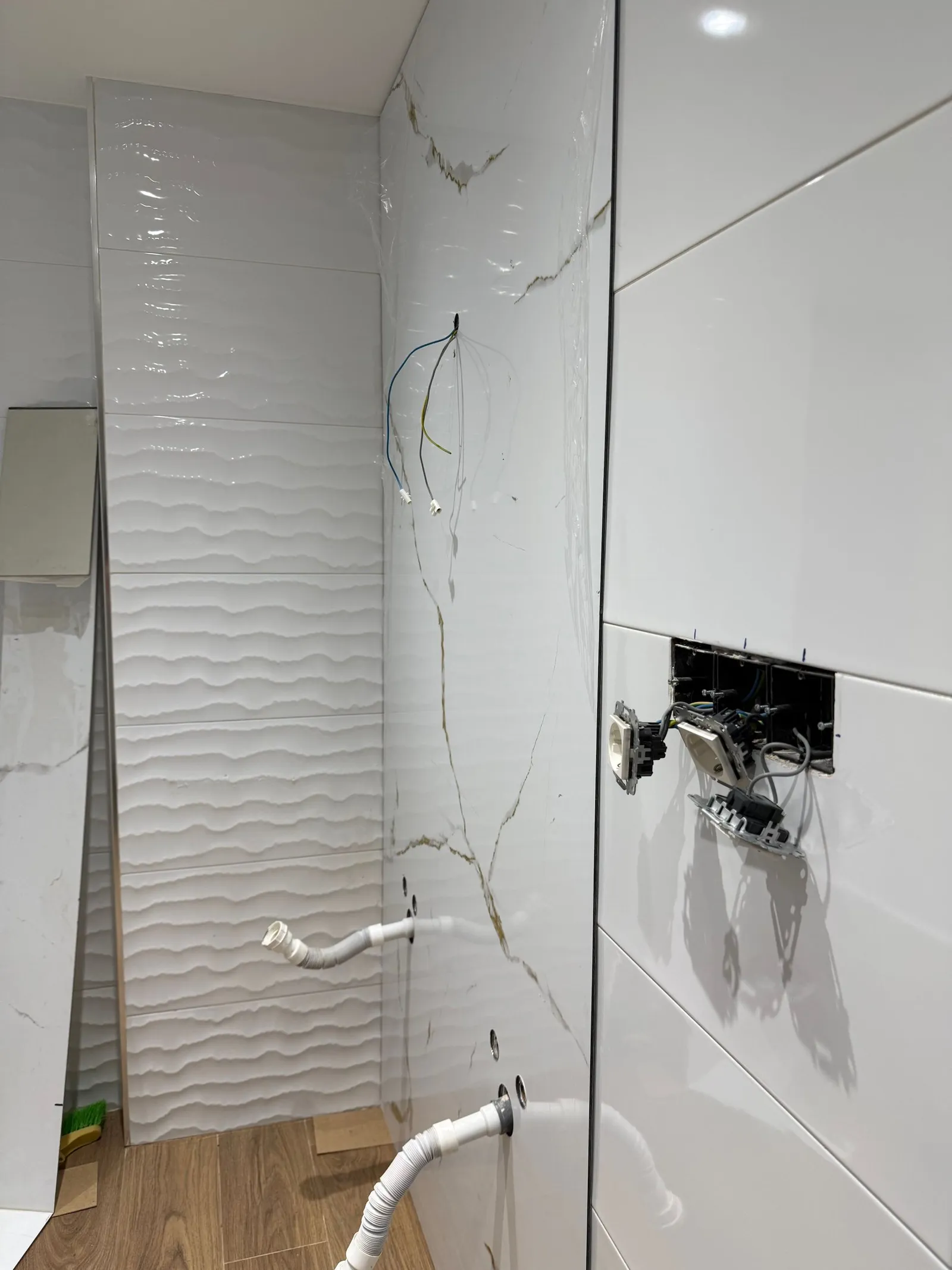 Baño durante la obra, con los paneles Kobert In colocados sobre el alicatado anterior
