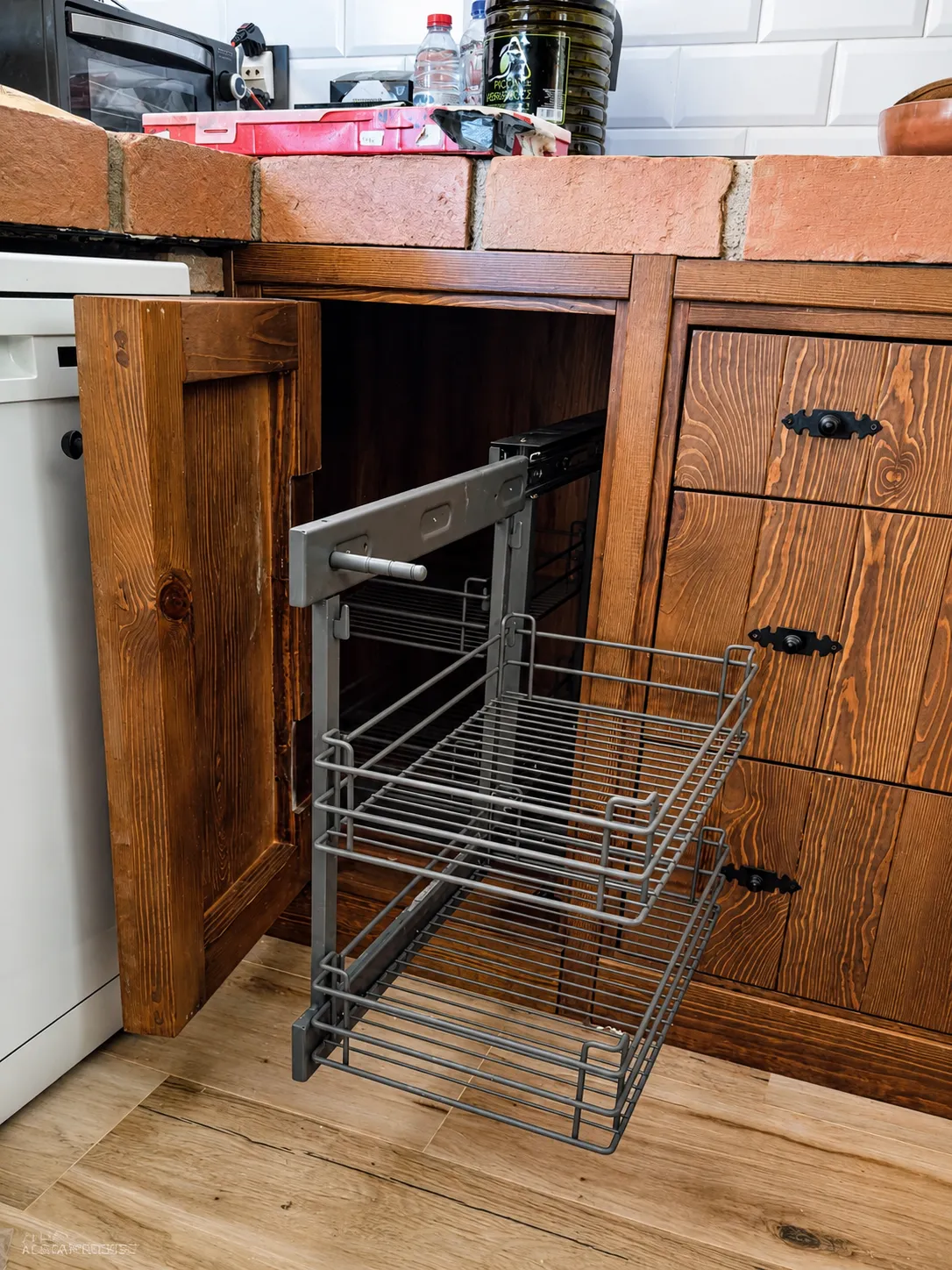 Cestas extraíbles metálicas dentro de un mueble bajo de madera rústica