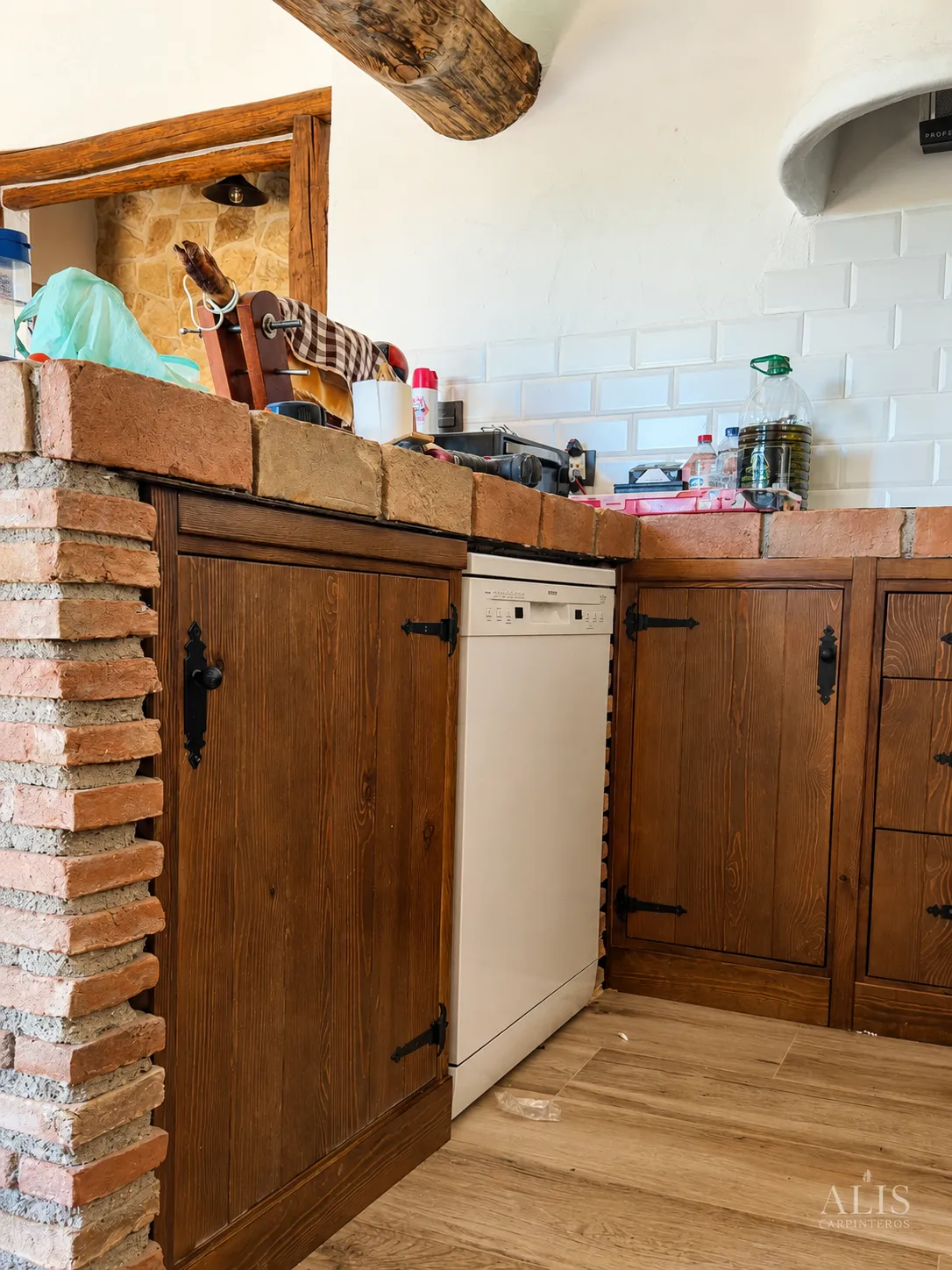 Muebles rústicos de madera con hueco para lavavajillas bajo encimera de ladrillo