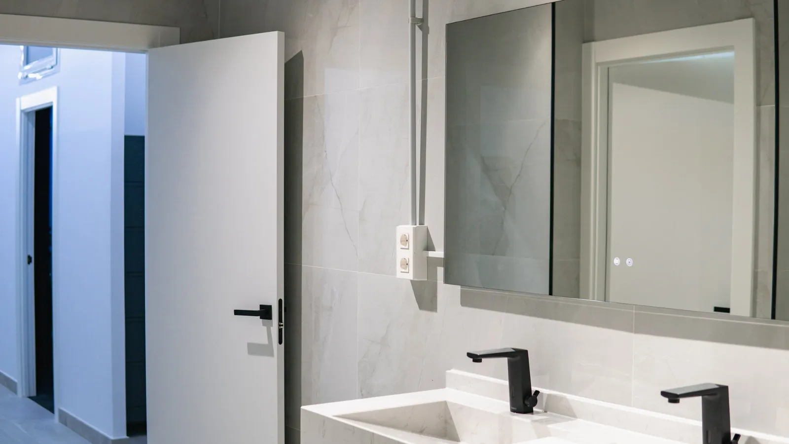 Baño con puerta de paso lacada en blanco y manilla negra