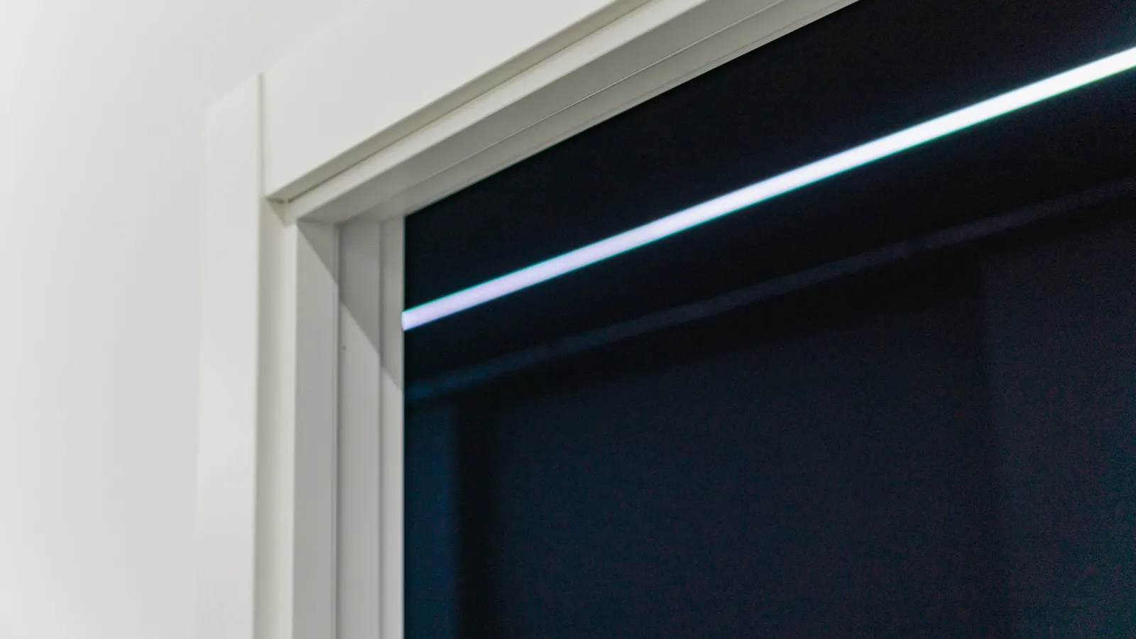 Detalle de esquina de marco lacado en blanco con tira de luz LED
