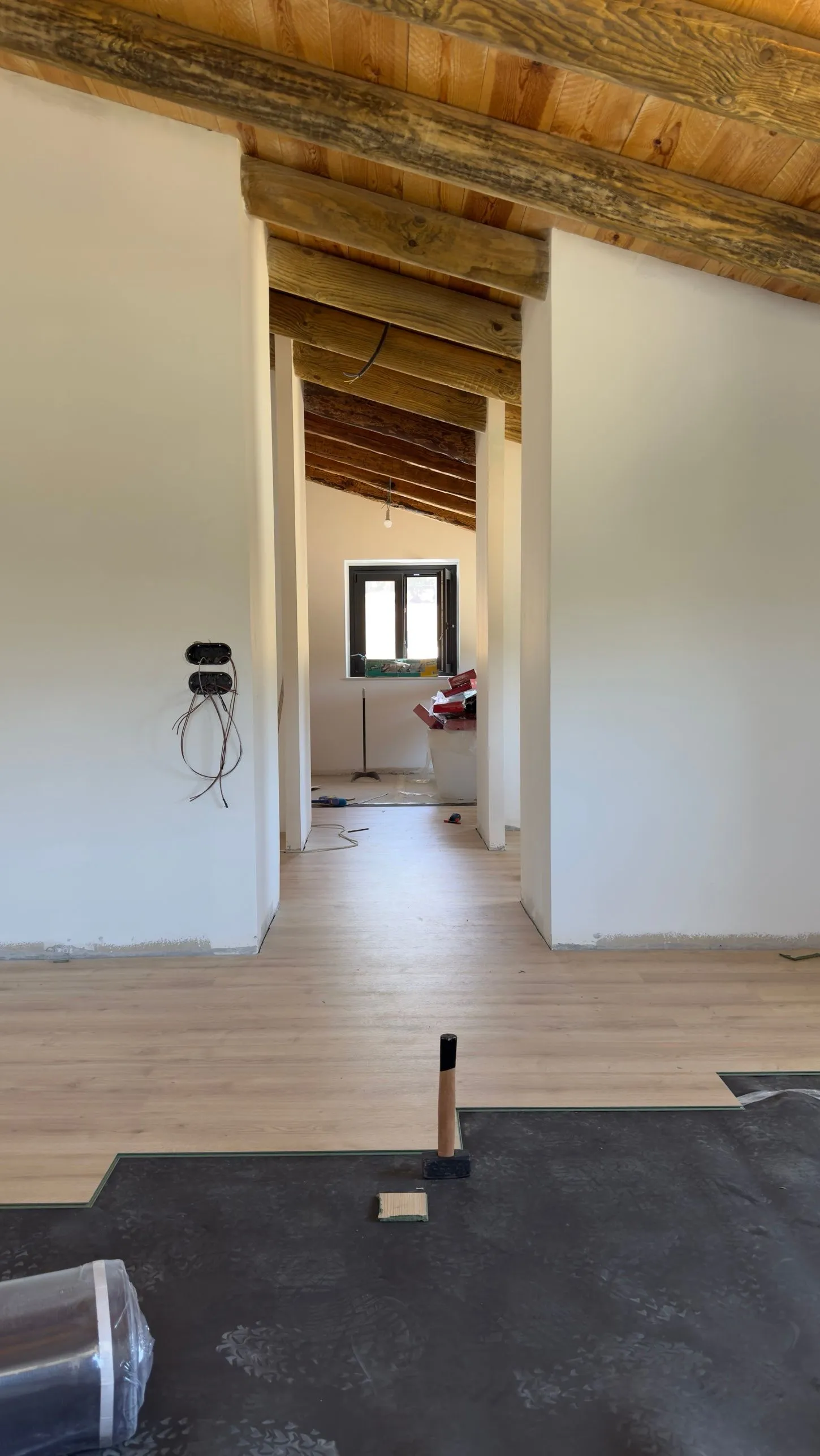 Pasillo de la buhardilla con vigas de madera durante la colocación del suelo